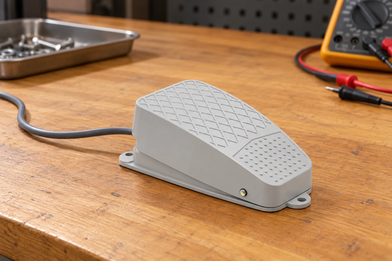 Grey LF reference foot pedal with loose cable and unconnected meter on wooden desk