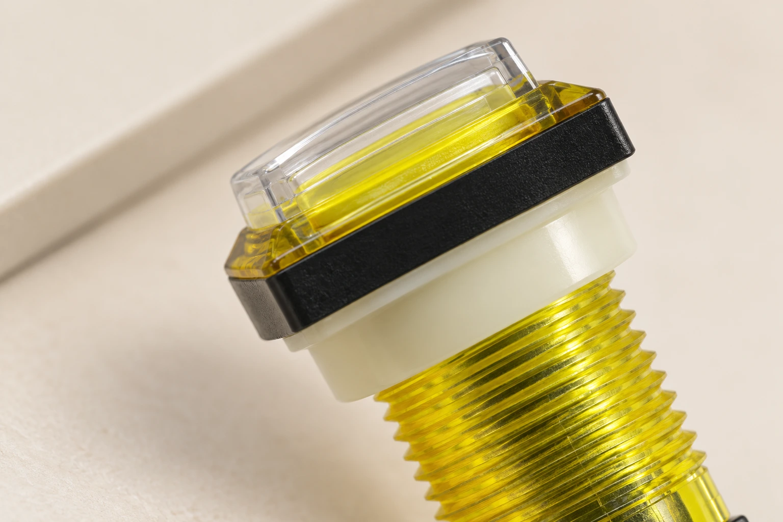 Close-up of the LEMA PBS clear cap, cream shoulder and yellow threaded mounting barrel